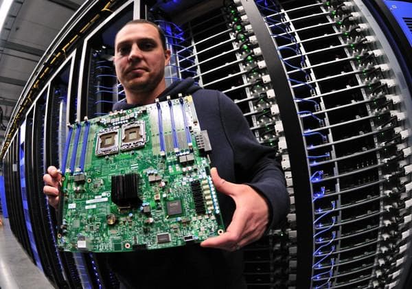Technikas laiko atvirą serverio pagrindinę plokštę duomenų centro serverių fone